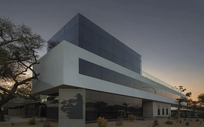 Madiba’s Corner: a white cantilevered office building at dusk