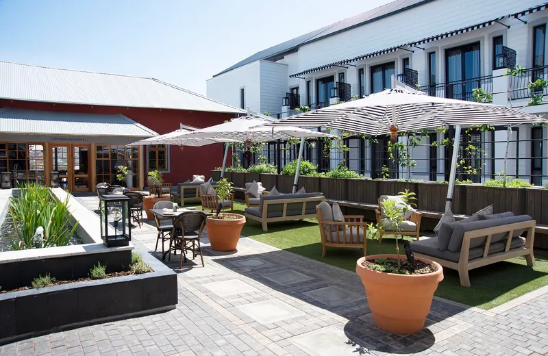 The hotel courtyard with umbrellas, planters and lounge seating